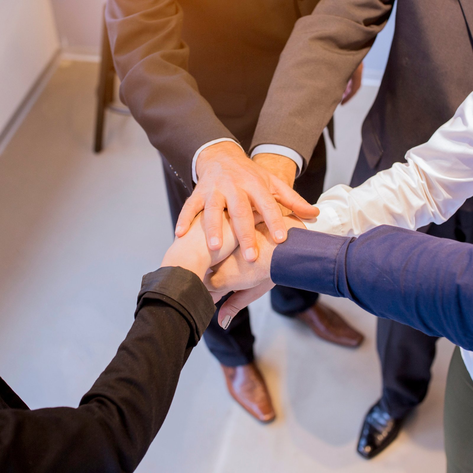 close-up-businesspeople-stacking-hands-meeting-office